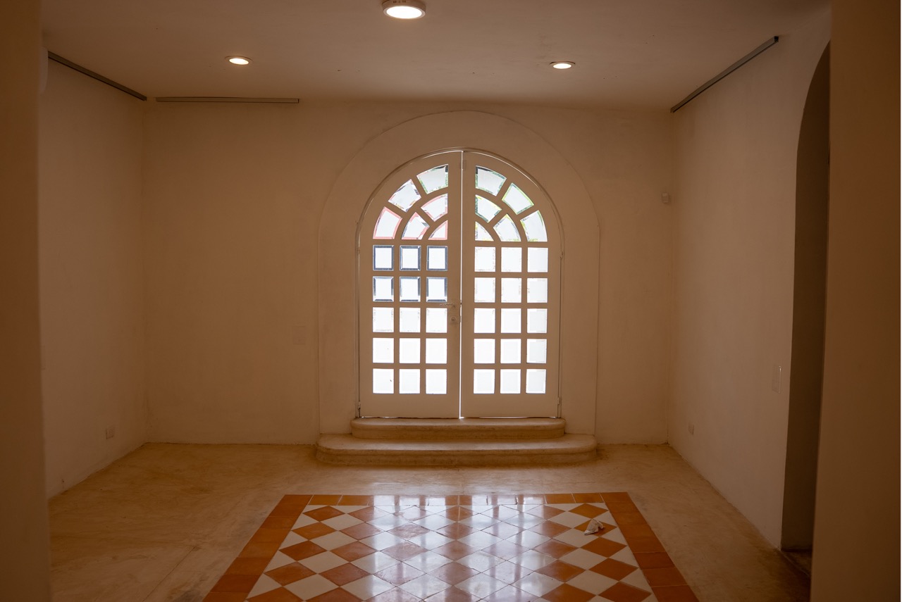 Salón de exposición con puerta de arco y piso de pasta en CoGallery