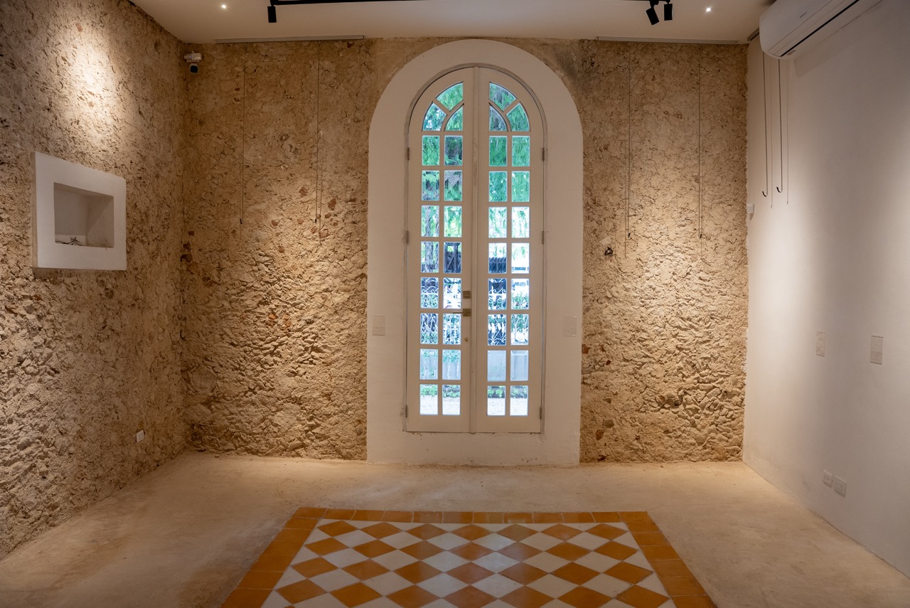 Interior de salón con muros de piedra y puerta de arco en CoGallery